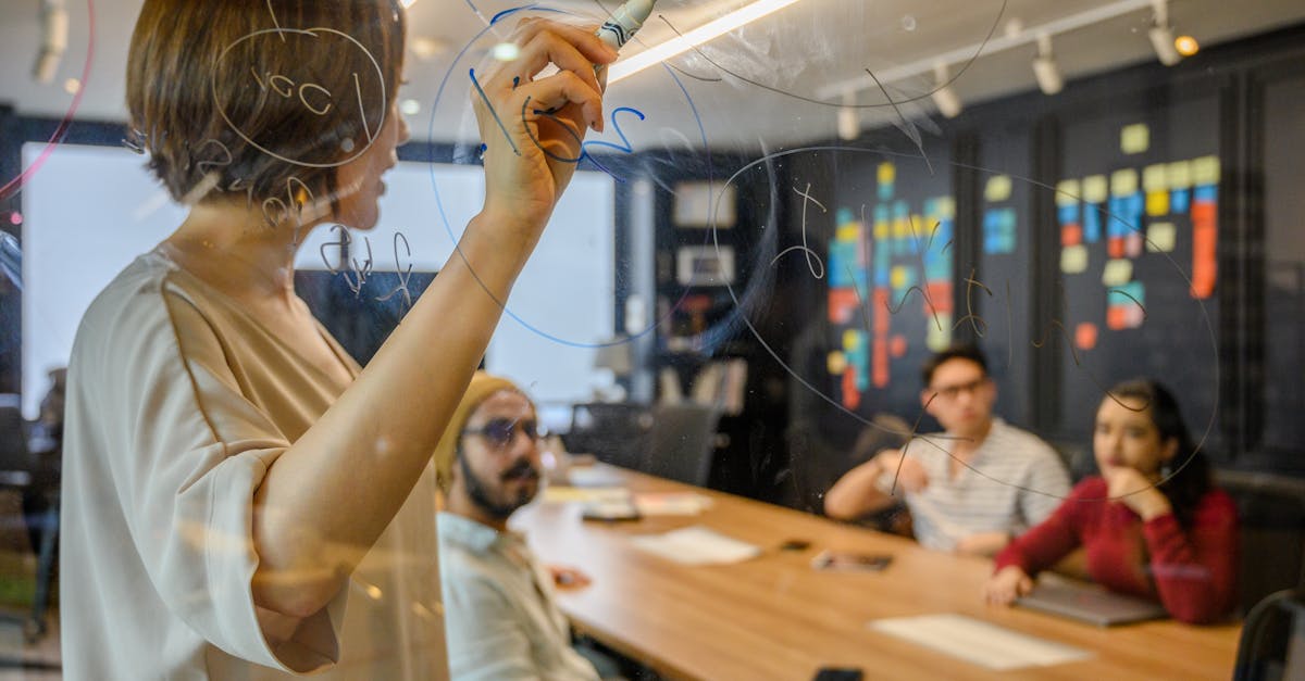Team members brainstorm with ideas on a clear board in a modern office setting.